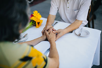 couple holding hands at the dinner table