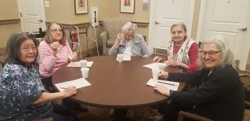 memory care word search with five women sitting around a table