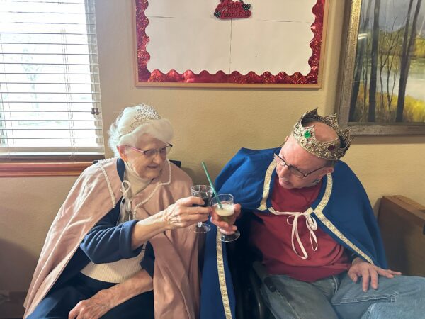 two seniors toasting a glass for a valentines day activity 