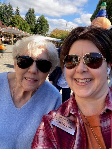 two women smiling into the camera while on a life enrichment outing to the local pumpkin patch